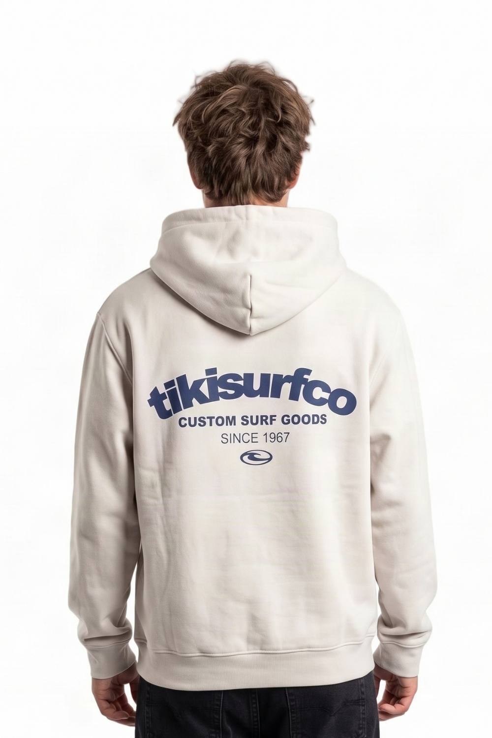 A man viewed from behind wearing a light beige hoodie with a navy blue 'tikisurfco' logo printed across the back, set against a plain white background.