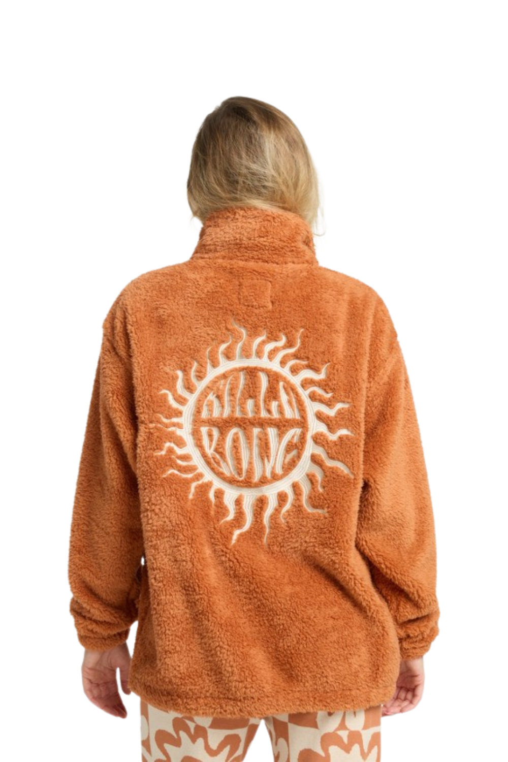 Person wearing an orange fleece jacket with a sun design and 'Wild One' text on the back.