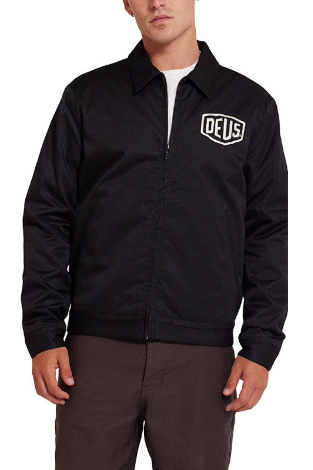 Black jacket with 'DEUS' logo worn by a person on a white background