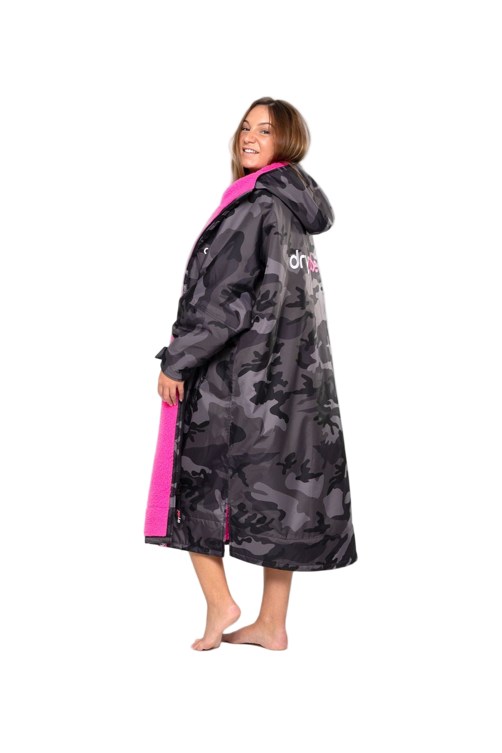 A person wearing a long sleeve black camo/pink Dryrobe Advance Adult standing against a white background.