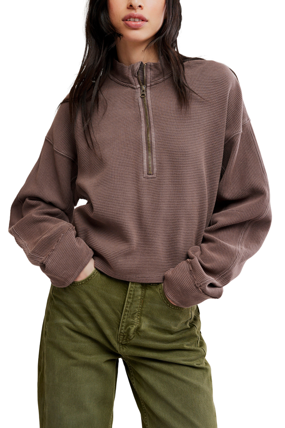 A woman wearing a ribbed brown quarter-zip pullover sweater and olive green pants, shown from the nose down against a plain white background.