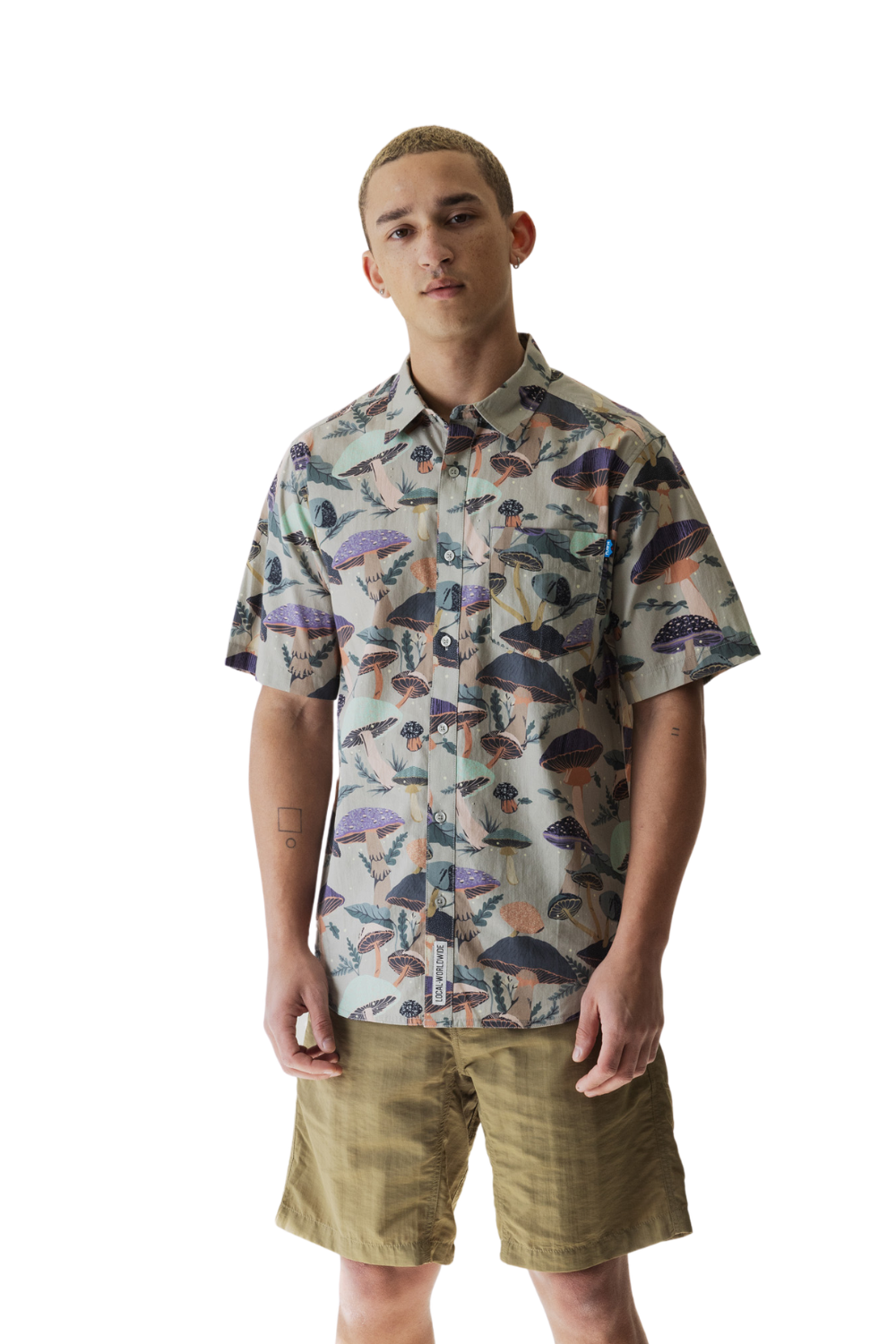 Man wearing a patterned shirt and shorts on a white background