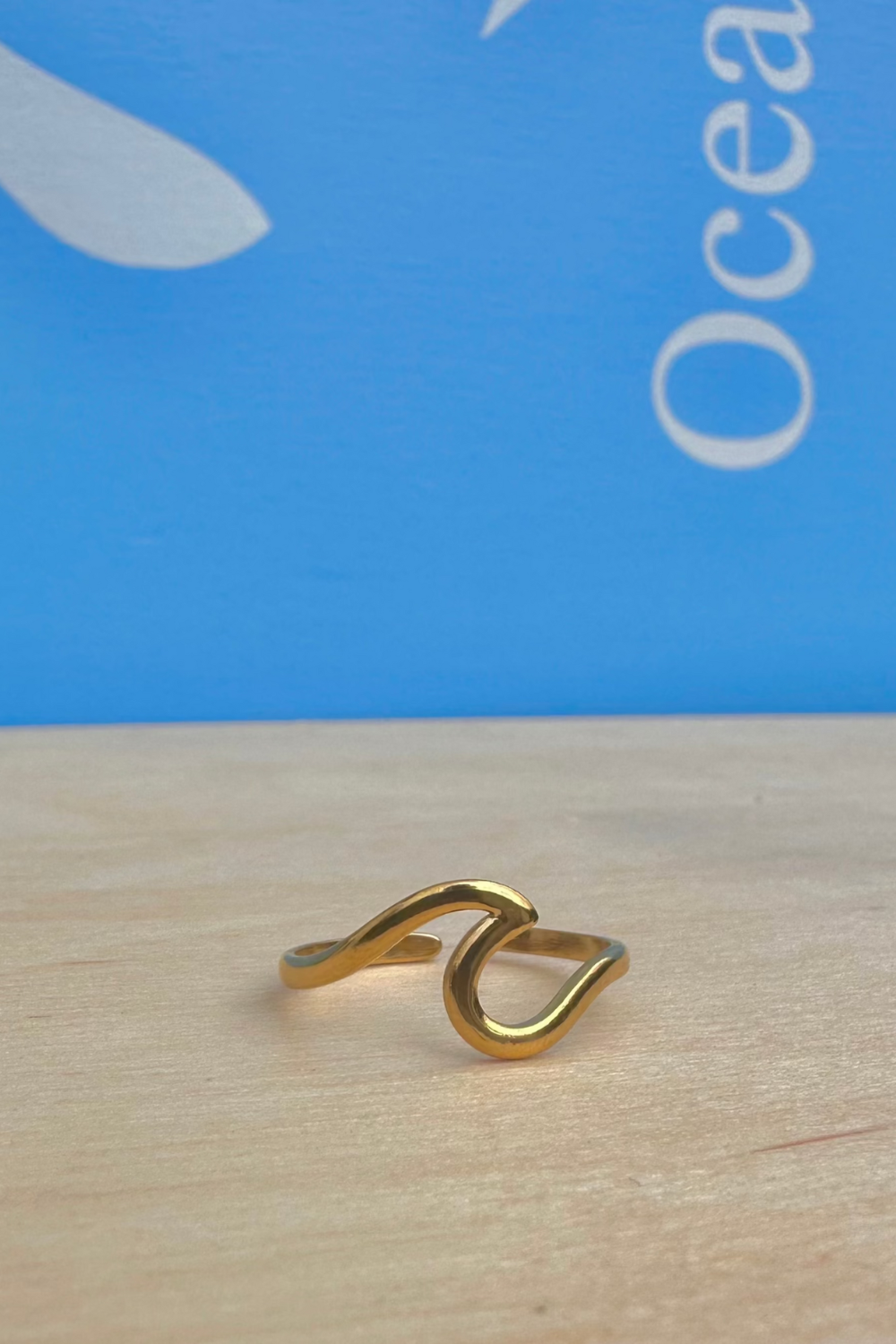 Gold ring on a wooden surface with a blue background