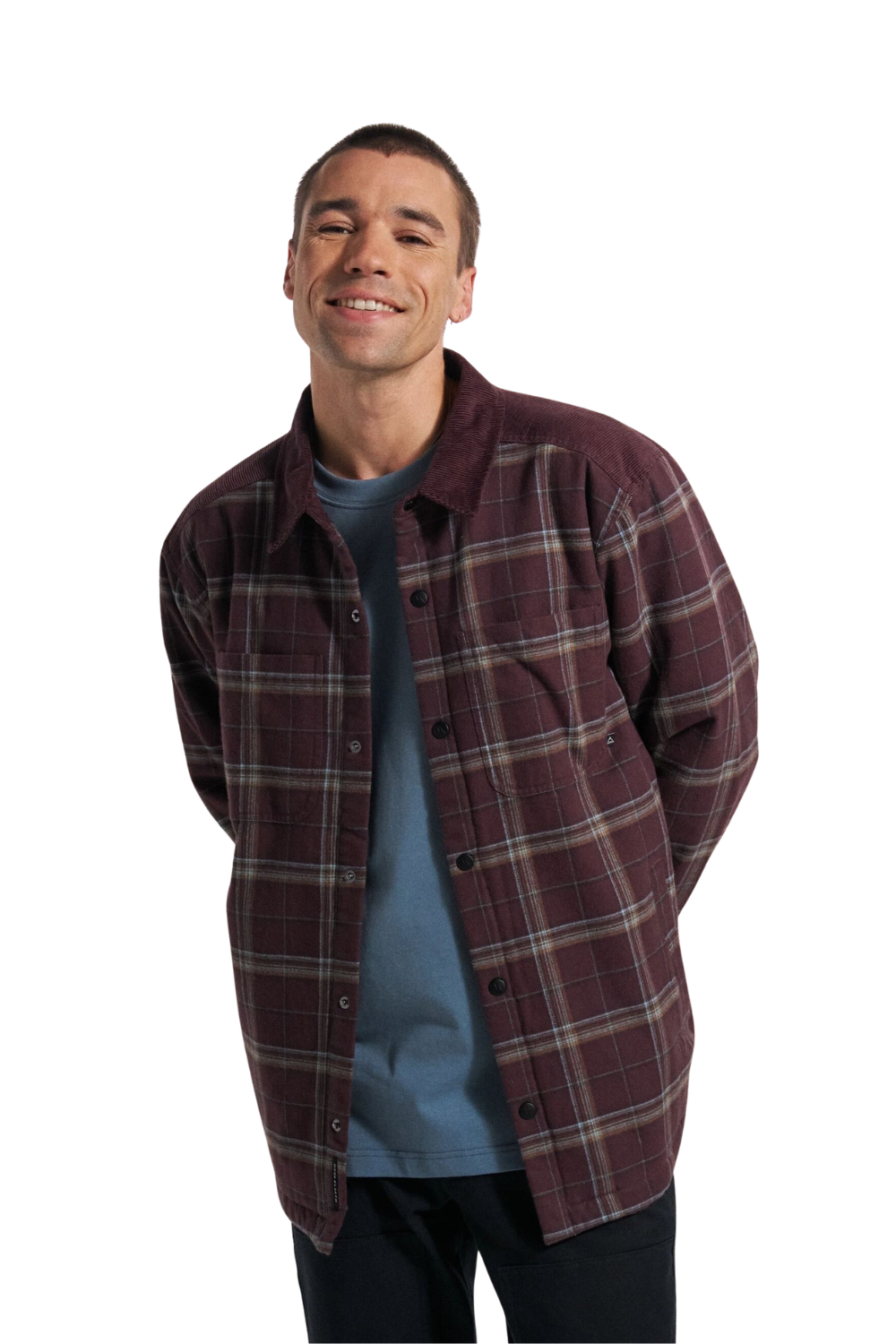 A man wearing a burgundy and brown plaid button-up flannel and sherpa lined overshirt paired with a blue t-shirt, photographed against a solid white background.
