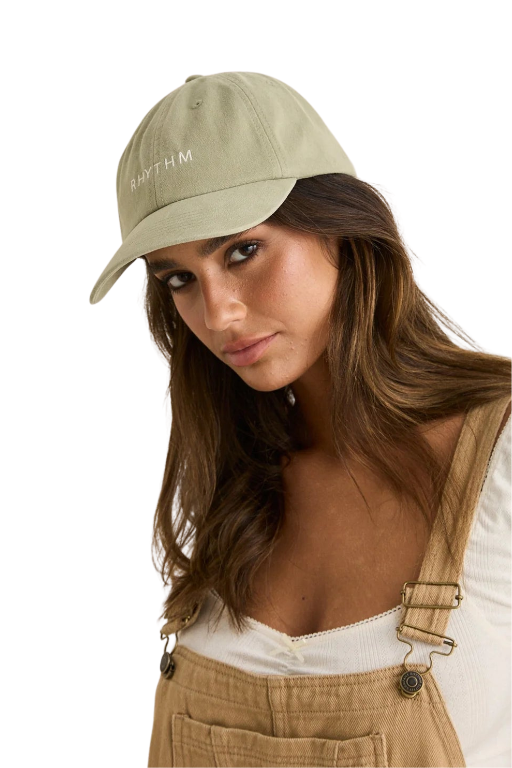 Woman wearing a beige cap with a white Rhythm logo on the front