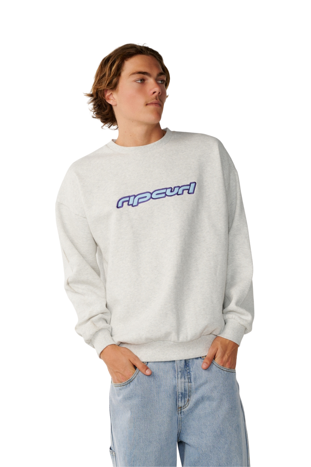 A young man wearing a light gray heather crewneck sweatshirt with a blue and purple 'ripcurl' logo across the chest, paired with light blue jeans, set against a plain white background.