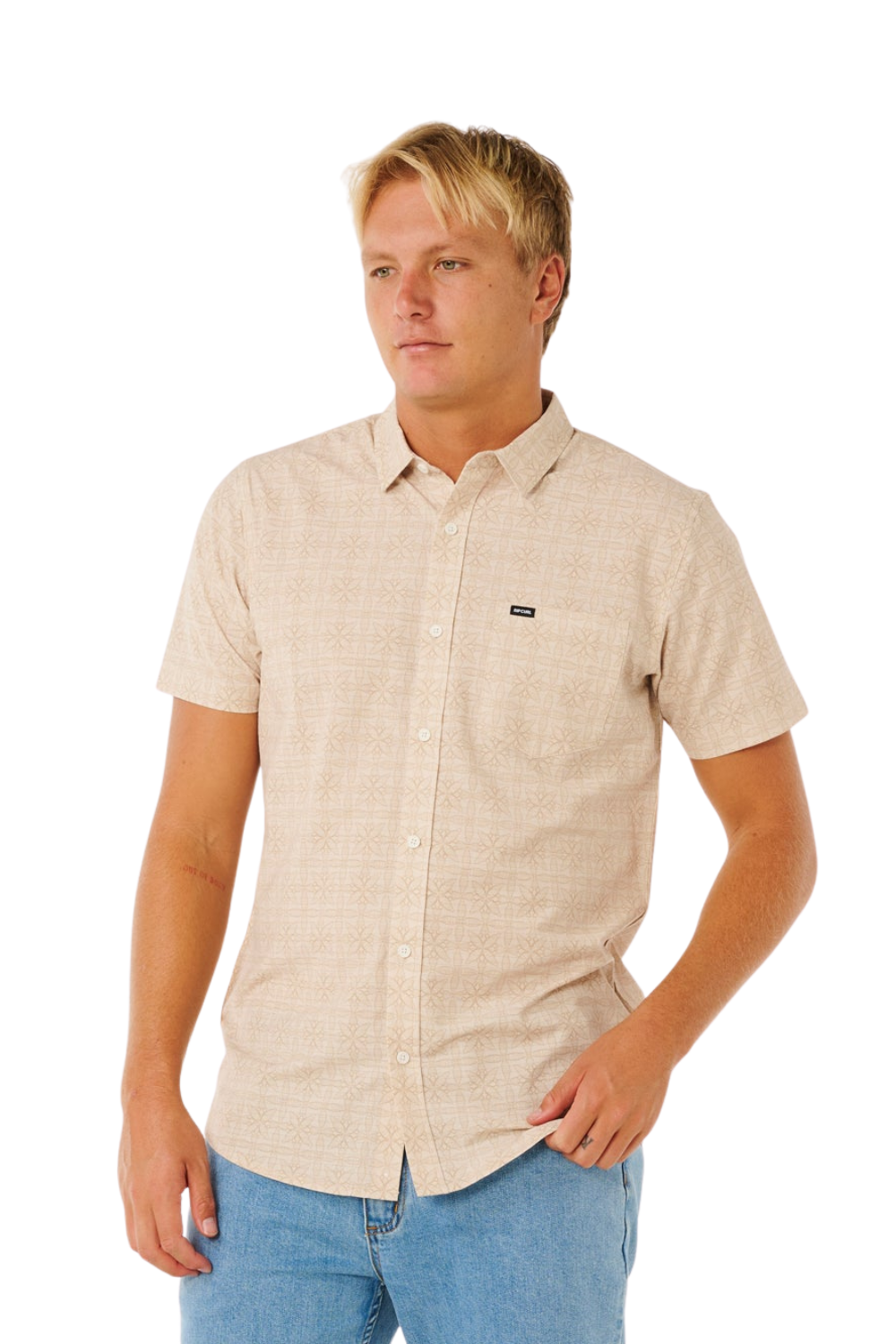 Man wearing a beige short-sleeve shirt with a small logo on a white background