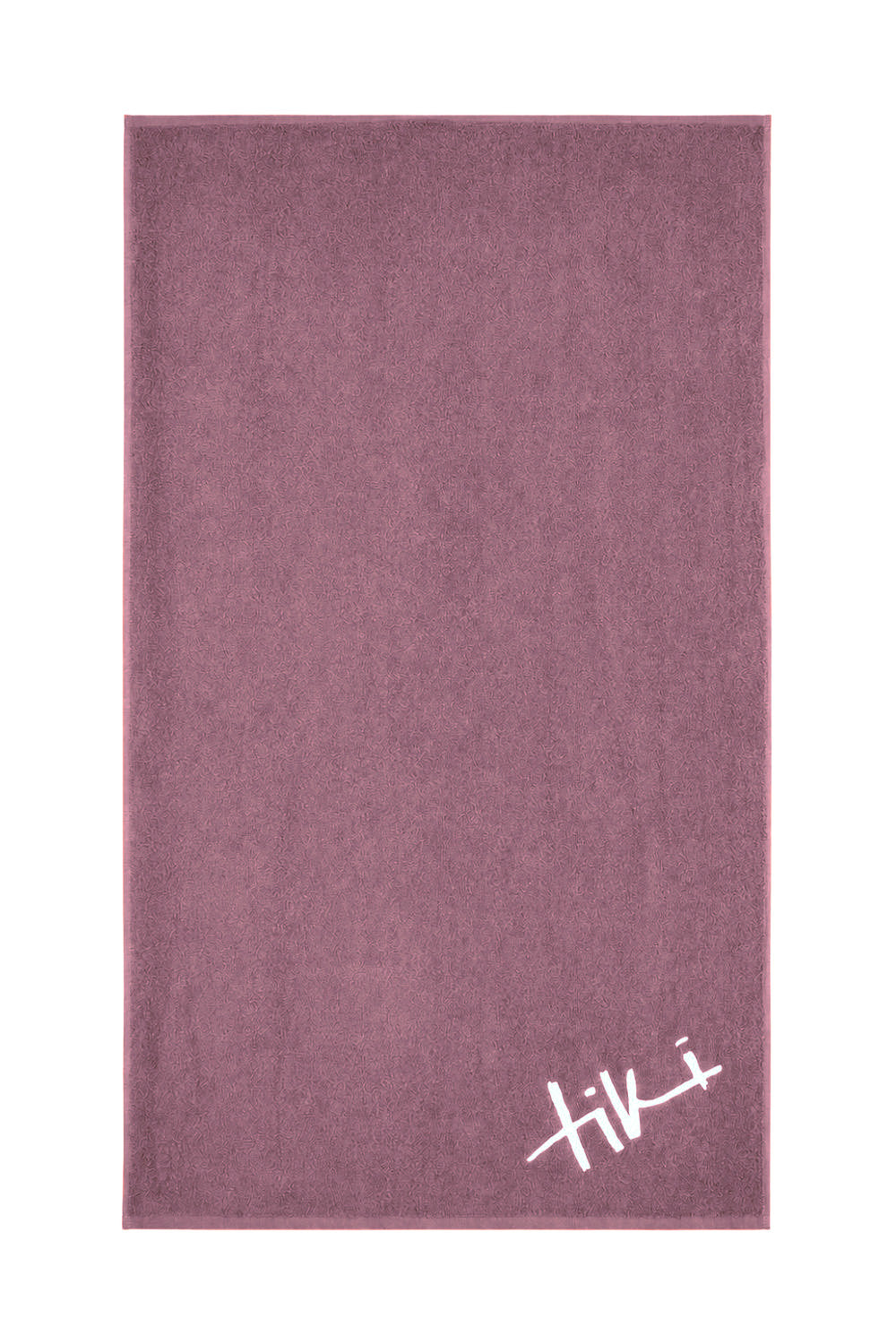 A mauve coloured beach towel with a white Tiki logo on the right hand corner shown on a white background.
