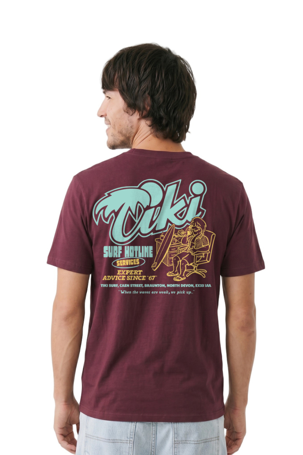 Man wearing a maroon t-shirt with a graphic design on the back, standing against a white background