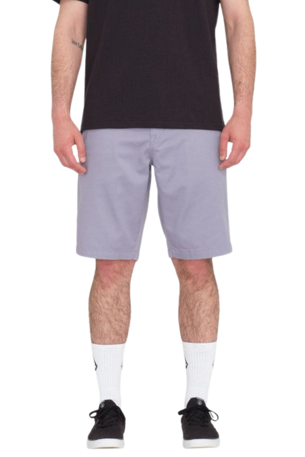 Person wearing light purple shorts and black shoes on a white background