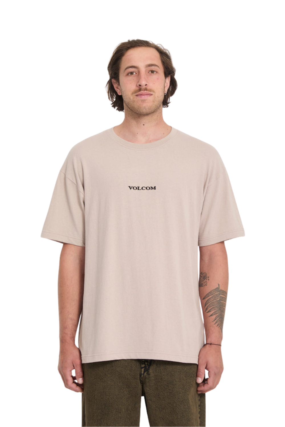 Man wearing a beige t-shirt with Volcom logo on a white background
