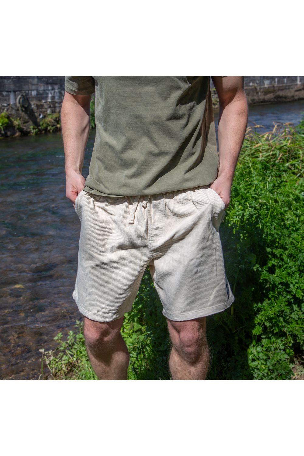 Bamboobay Cord Shorts in Sand yellow on a model front view with hands in pockets
