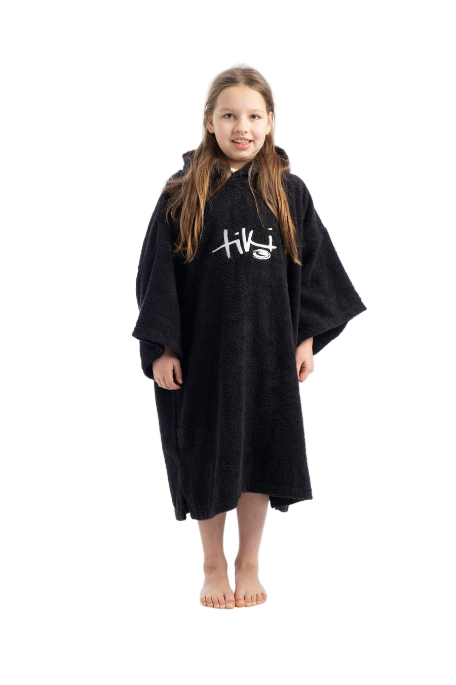 A child wearing a black hooded change robe with the Tiki logo on the chest.