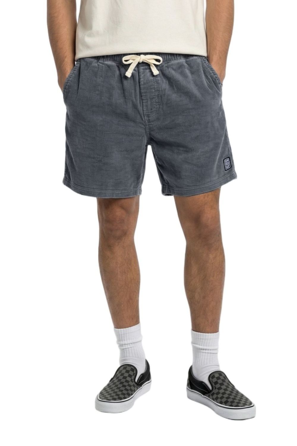 Person wearing blue corduroy shorts with a brand logo on a white background
