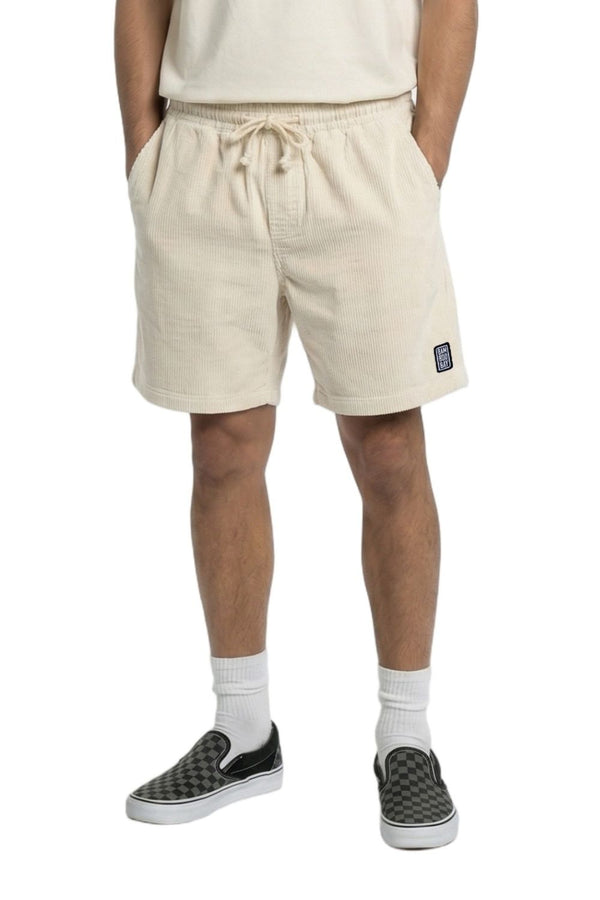 Person wearing beige shorts on a white background