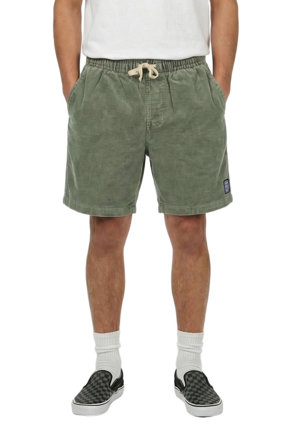Person wearing green corduroy shorts with a brand logo on a white background