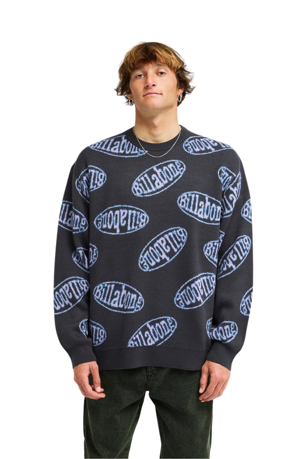A man wearing a dark gray crewneck sweater with a repeating light blue and purple 'Billabong' logo pattern, paired with dark green pants, against a solid white background.