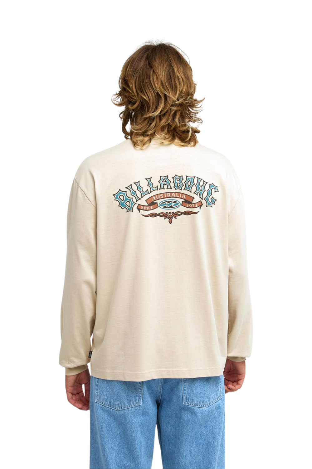 A person shown from the back wearing a cream-colored long-sleeve t-shirt with a large Billabong graphic on the back, paired with light blue jeans, against a plain white background.