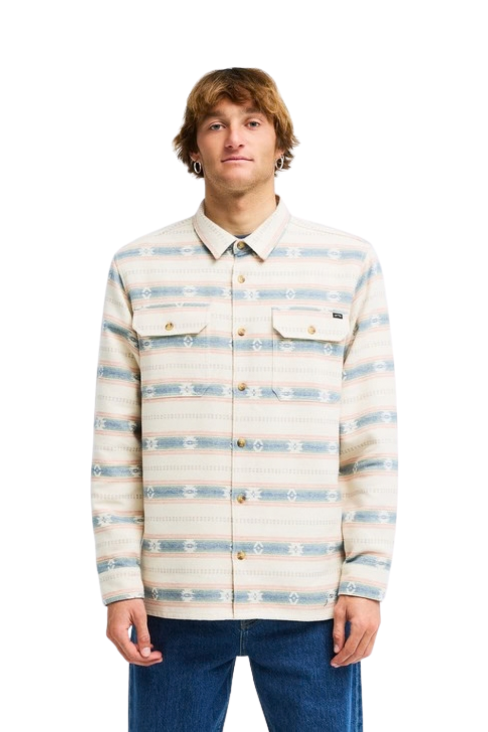 A man wearing a long-sleeve button-up shirt with a beige, white, and light blue horizontal patterned design, paired with blue jeans, against a plain white background.