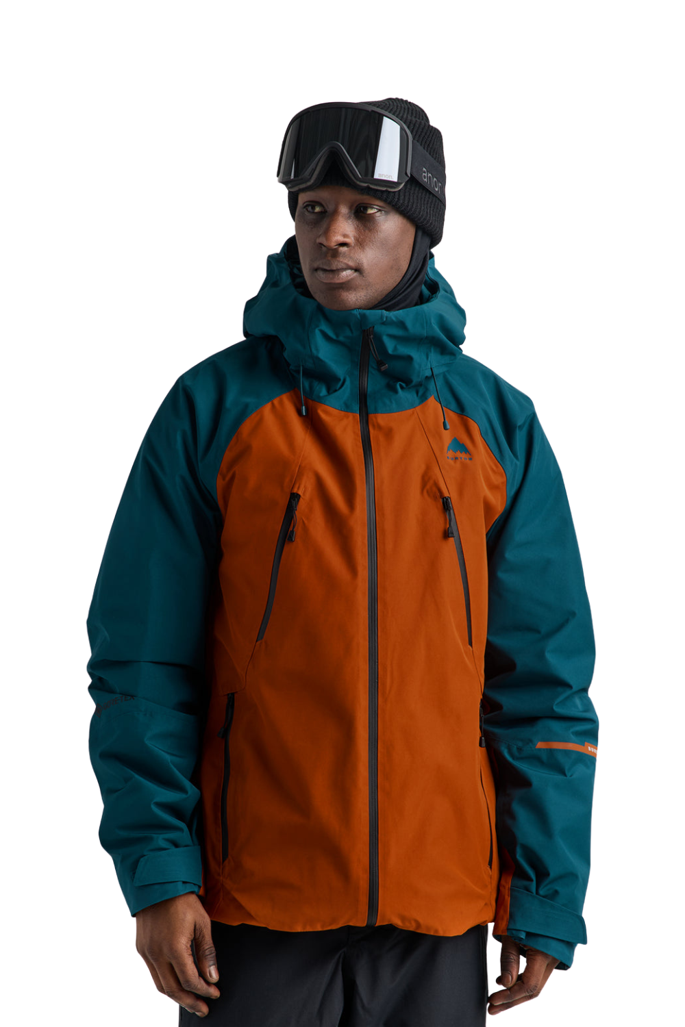 A man wearing a two-tone Burton ski jacket with a burnt orange front and teal sleeves, paired with a black beanie and ski goggles, against a solid white background.