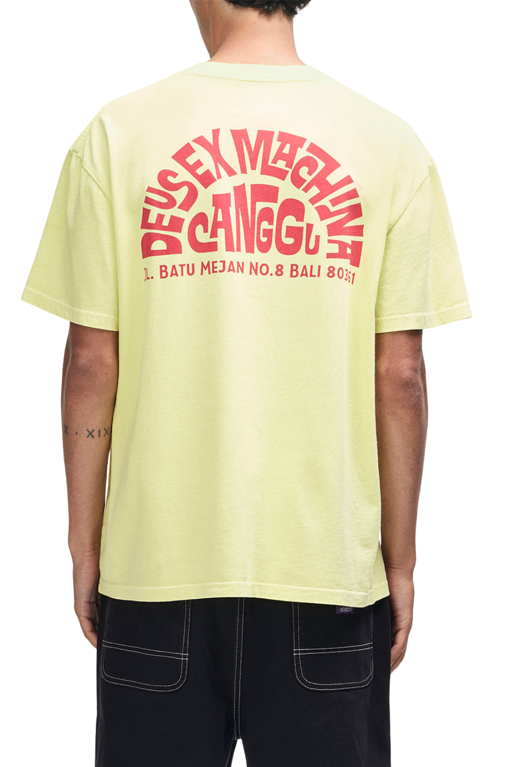 Person wearing a light yellow t-shirt with red text on the back, standing against a white background.