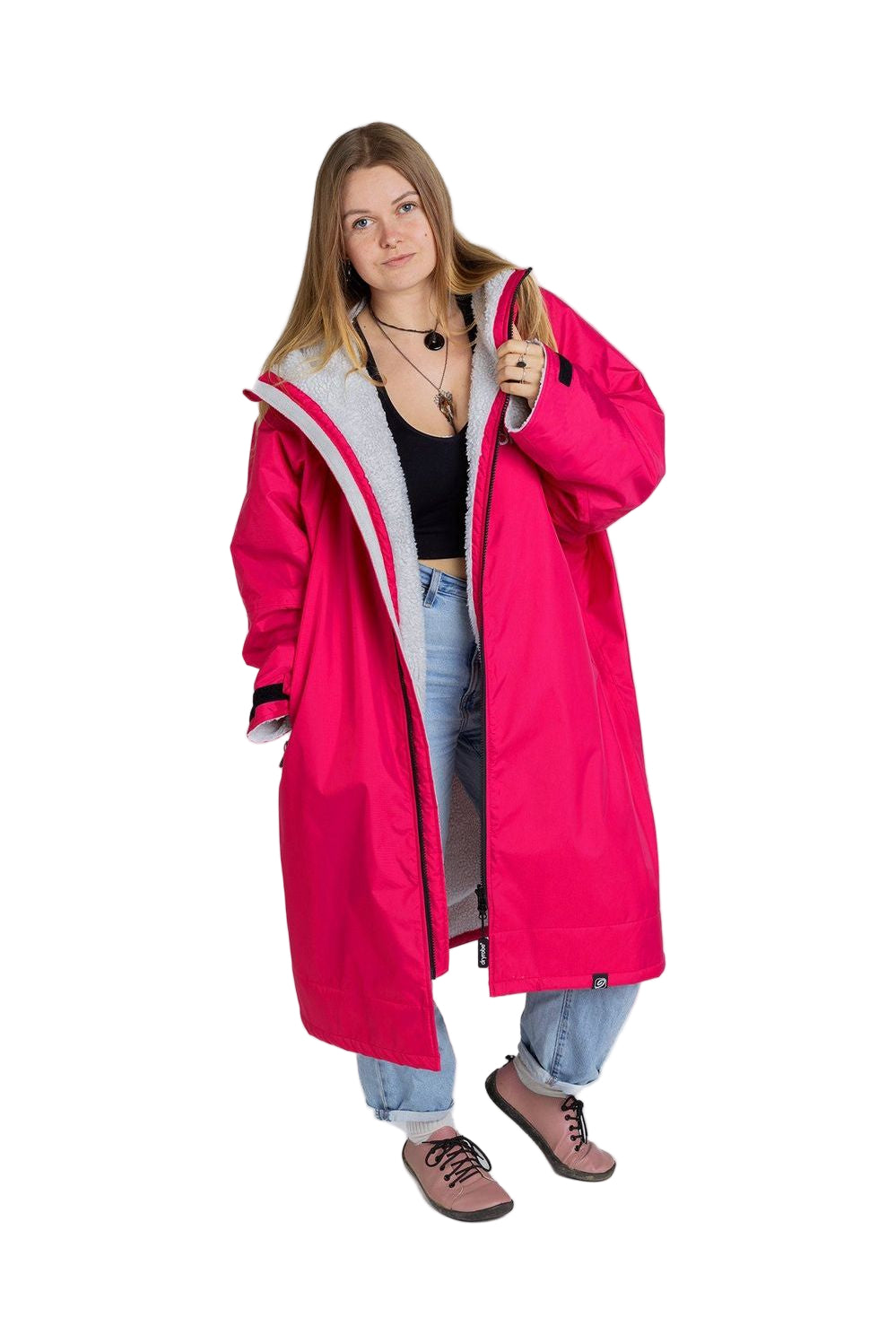 A person wearing a long sleeve pink light grey Dryrobe Advance, standing against a white background.