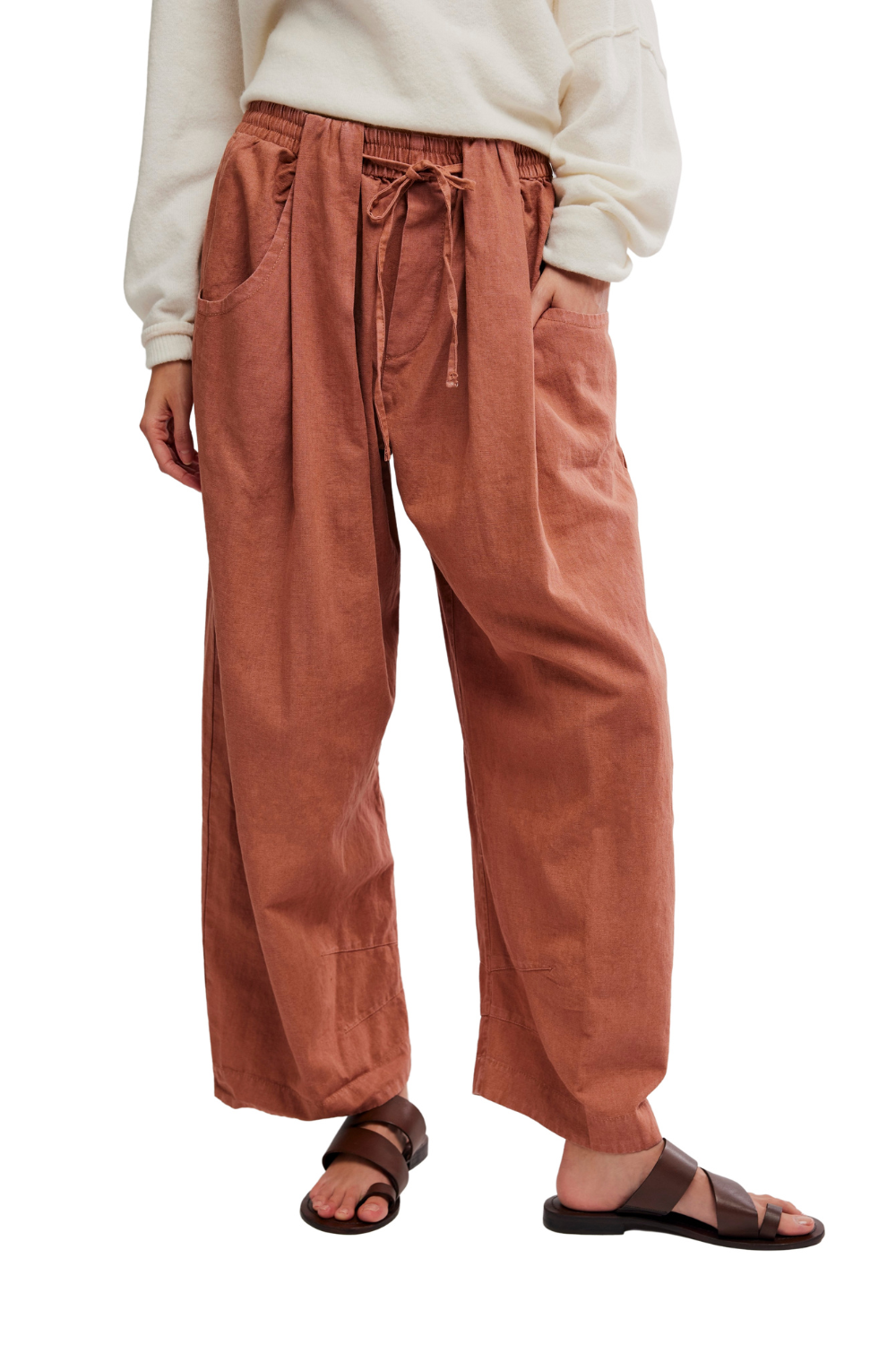 Person wearing rust-colored pants on a white background