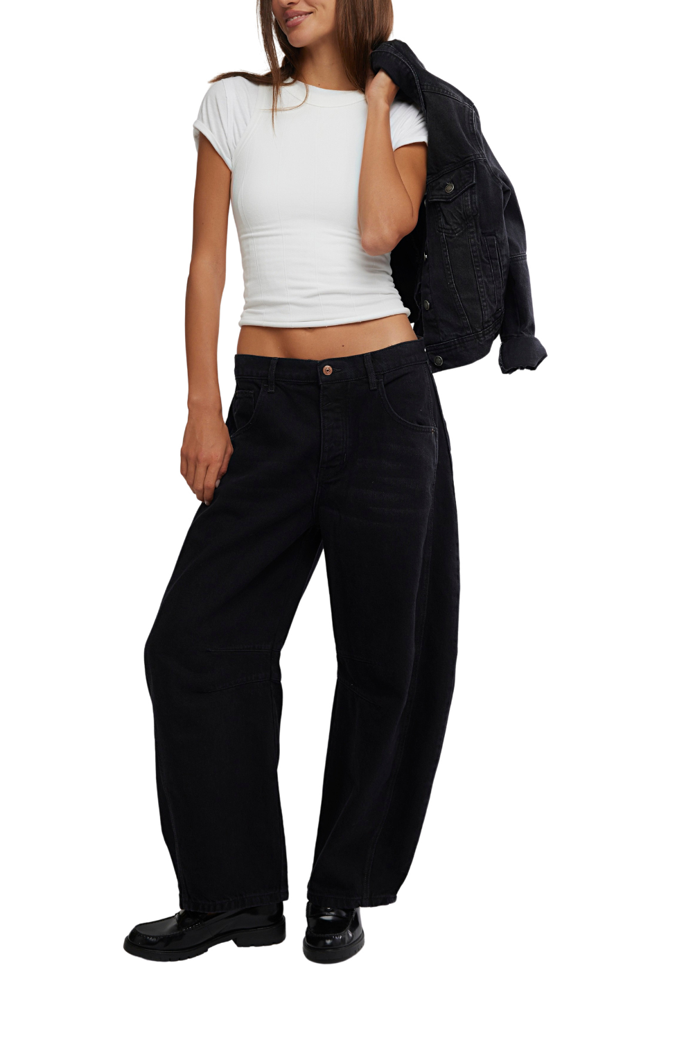 Person wearing a white crop top and black wide-leg pants, holding a black jacket.