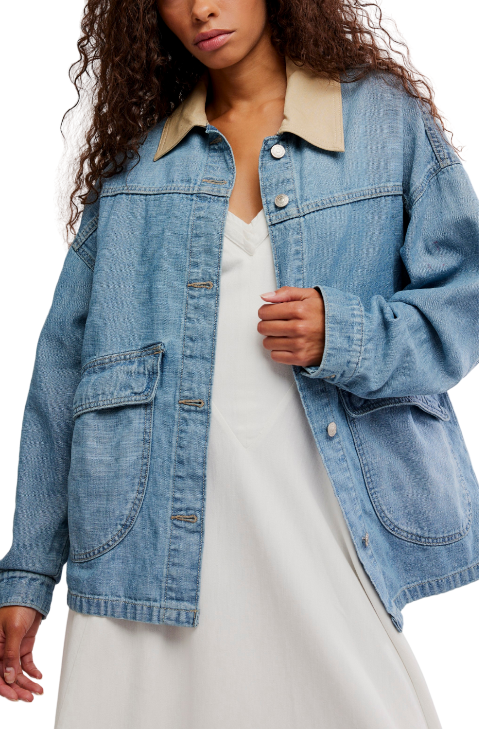 Woman wearing a blue denim jacket over a white dress
