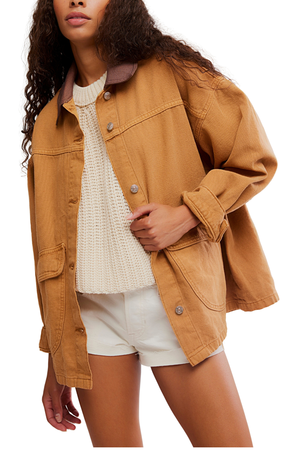 Woman wearing a brown jacket over a white top and shorts on a white background