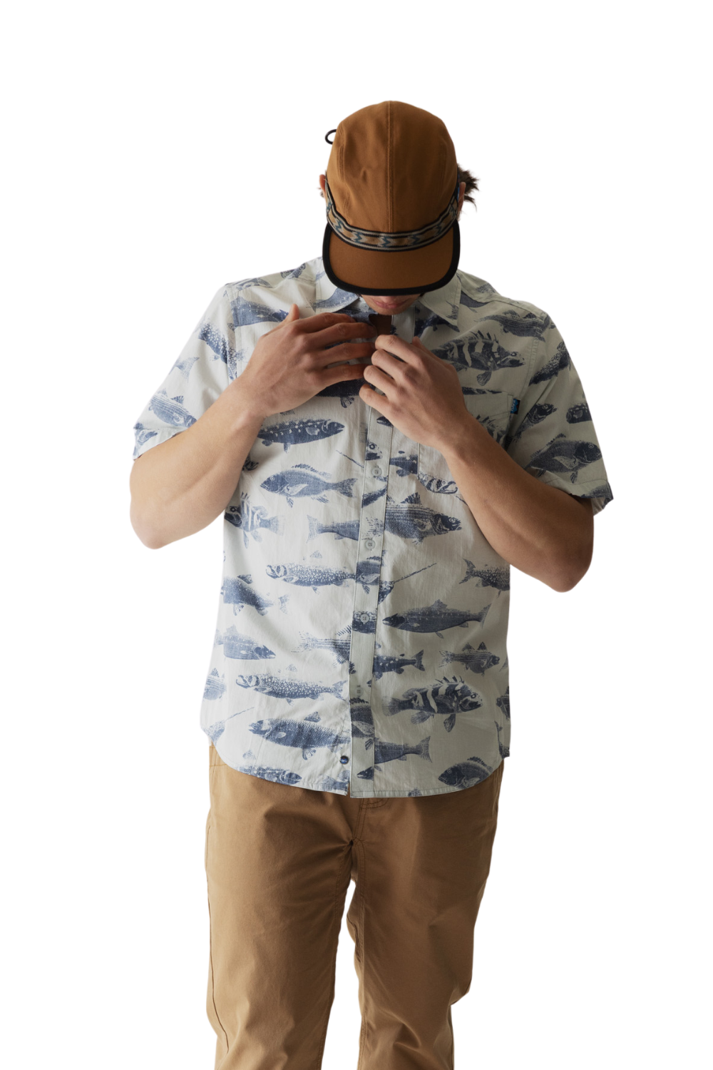 Person wearing a patterned shirt and brown cap on a white background