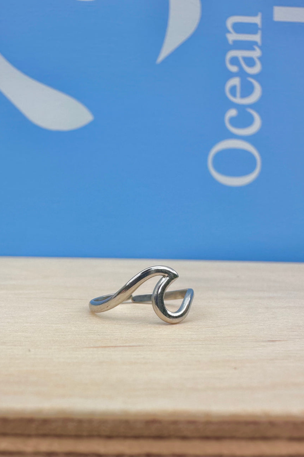 Silver ring on a wooden surface with a blue background 