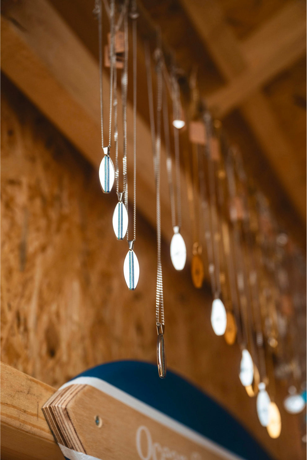 Jewelry with pendant necklaces hanging against a wooden background