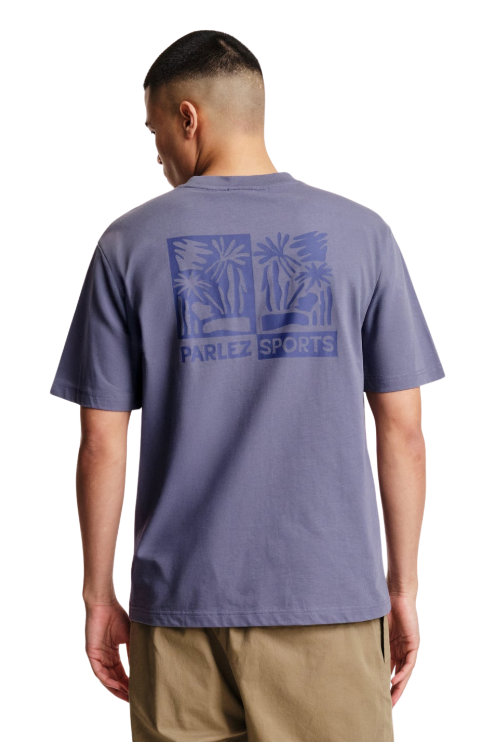 Person wearing a purple t-shirt with a logo and text on the back, standing against a white background