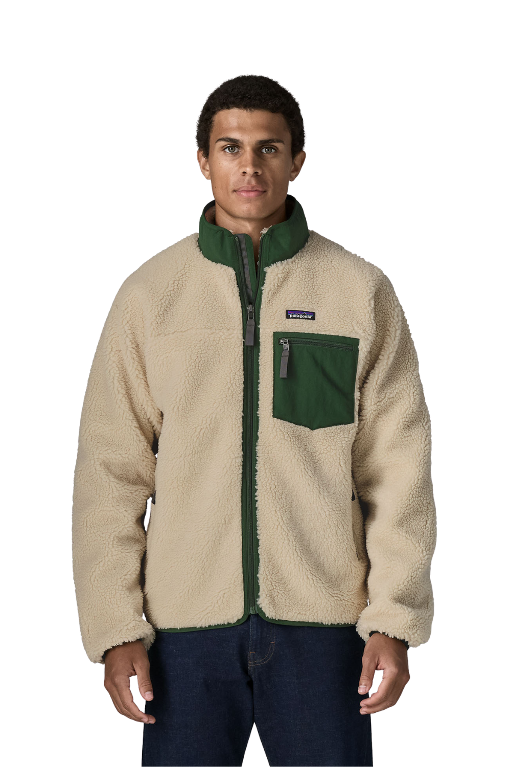A man wearing a Patagonia fleece jacket in beige and dark green, paired with dark blue jeans, photographed against a solid white background.
