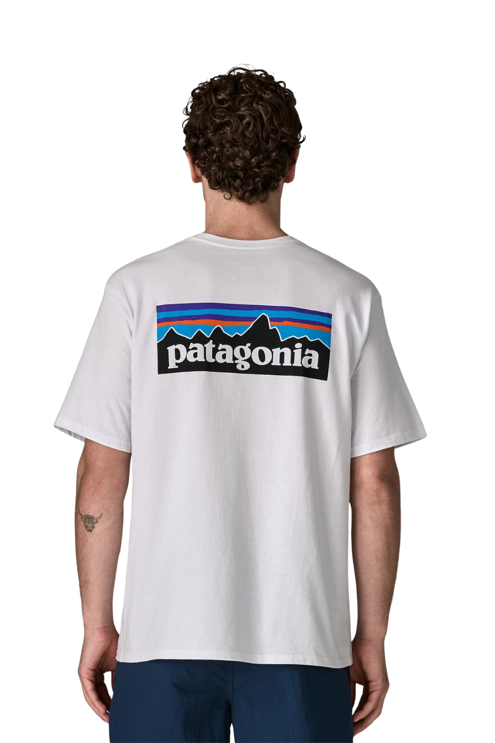A man viewed from behind wearing a white Patagonia t-shirt with the brand's signature multicolor mountain logo printed across the upper back.