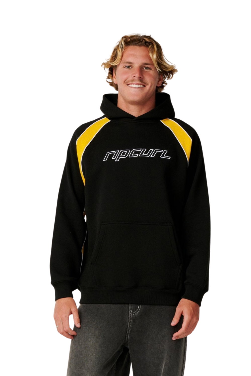 A man wearing a black Rip Curl hoodie with yellow shoulder panels and a white Rip Curl logo on the chest, paired with dark gray jeans, against a plain white background.
