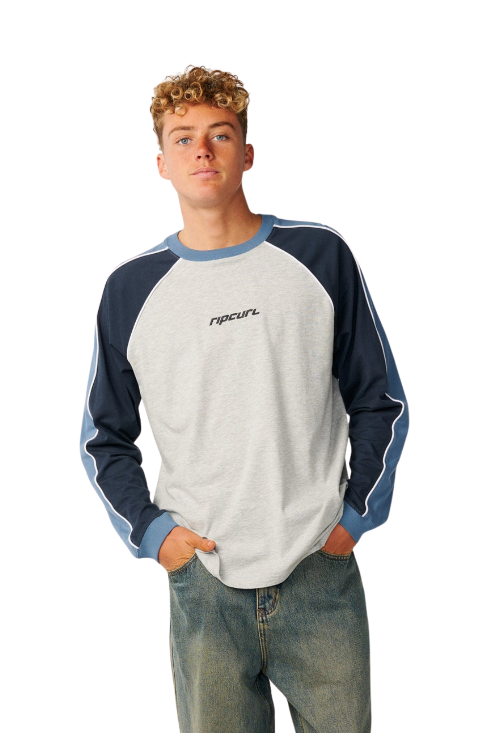 A young man wearing a grey, navy and blue long sleeved t-shirt with a 'Rip Curl' logo on the chest
