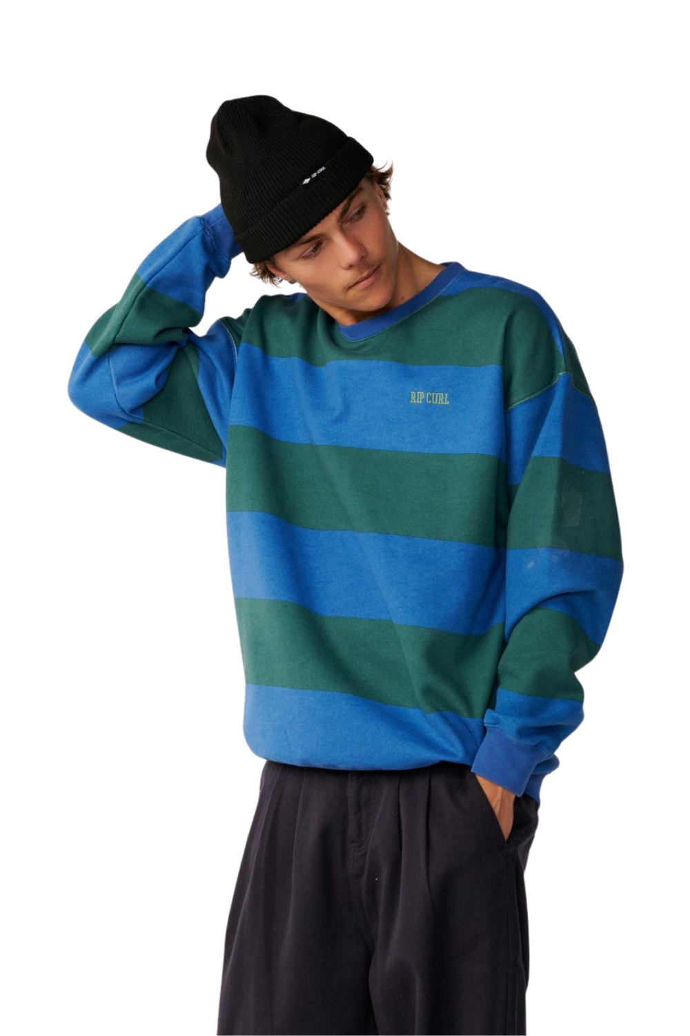 A model wearing a blue and green striped crewneck sweatshirt, a black beanie, and dark pants, posed against a solid white background.