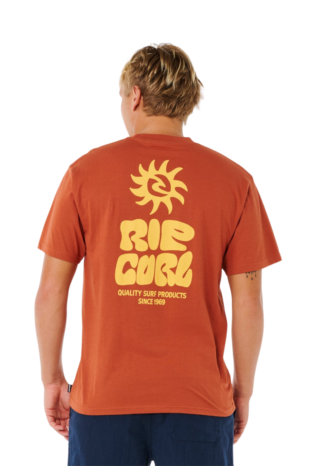 Person wearing a orange t-shirt with a bold Rip curl logon on the back.