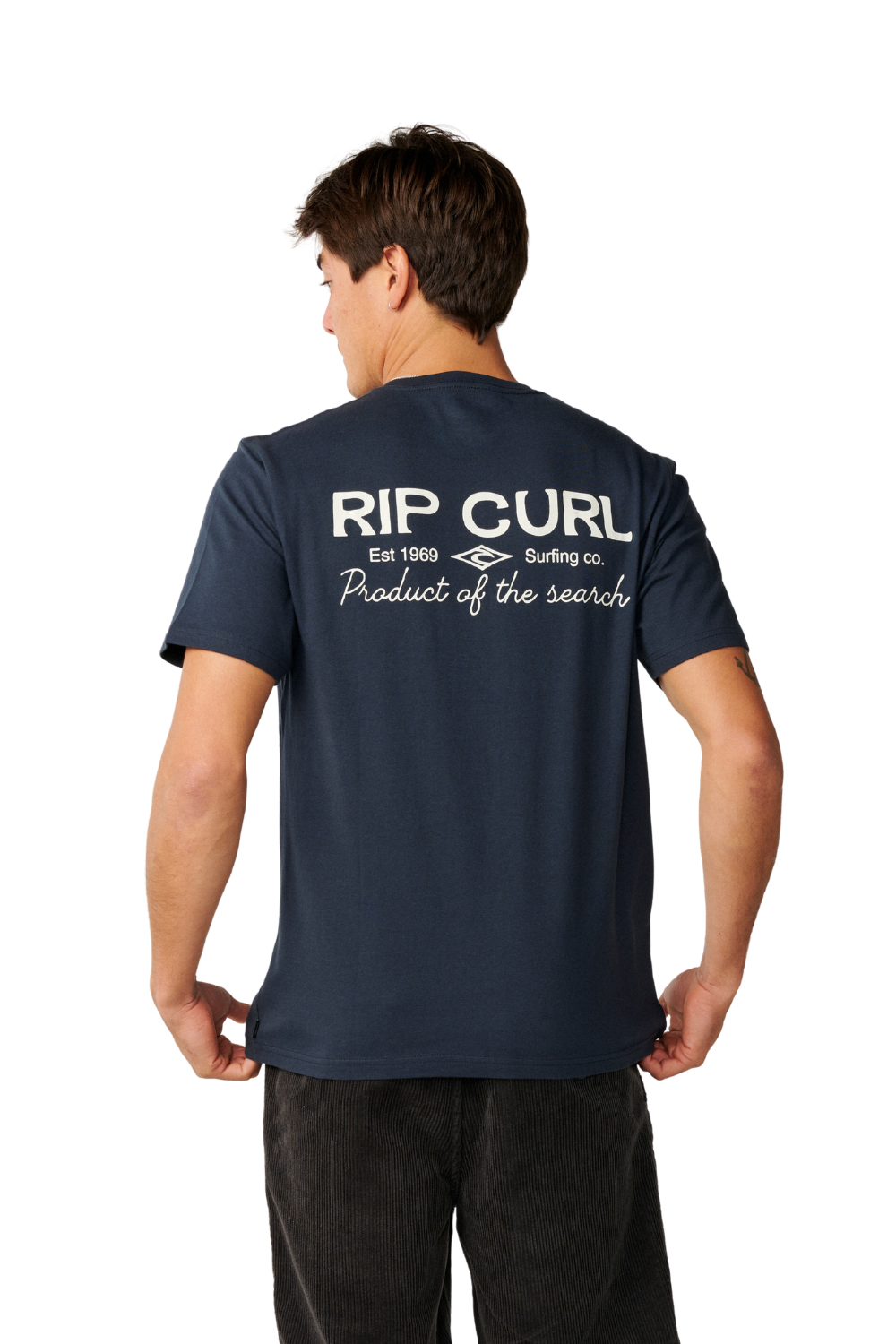 A man viewed from the back wearing a navy blue t-shirt with a white 'RIP CURL Surfing Co' graphic on the back, paired with dark pants, against a plain white background.