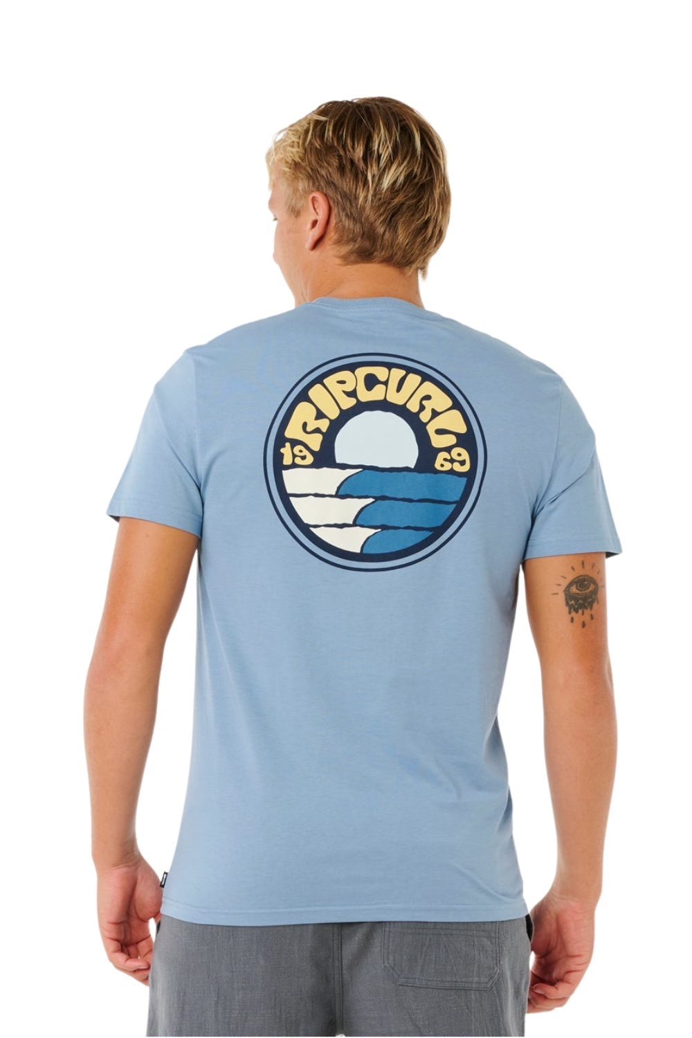 Person wearing a t-shirt in light blue with a bold Rip curl logon on the back