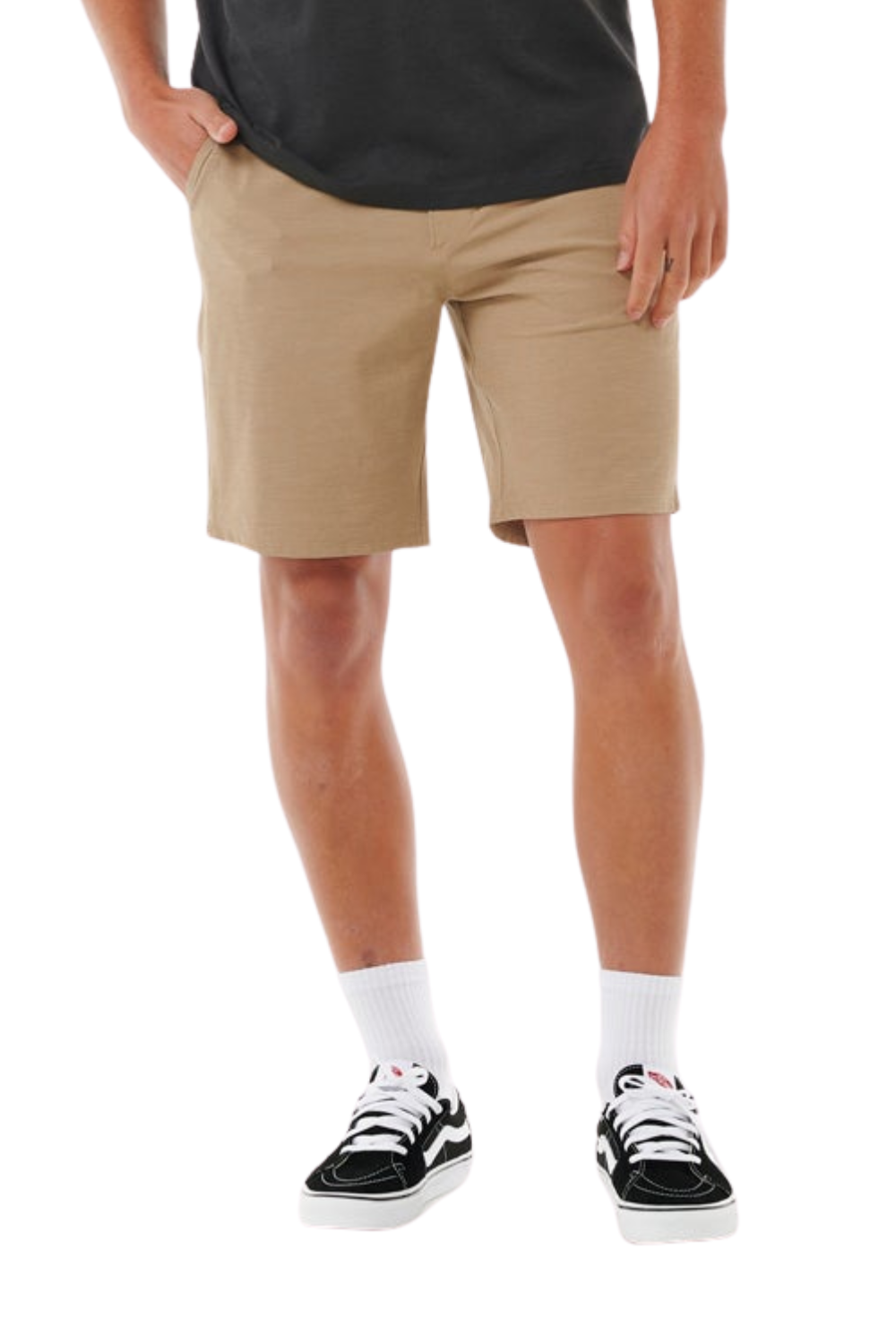 Person wearing beige shorts and black sneakers on a white background