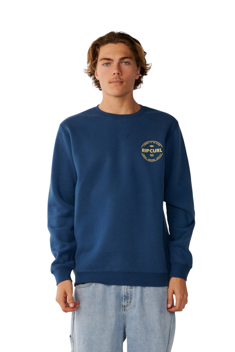 Man wearing a navy sweatshirt with a circular logo in yellow on the chest.
