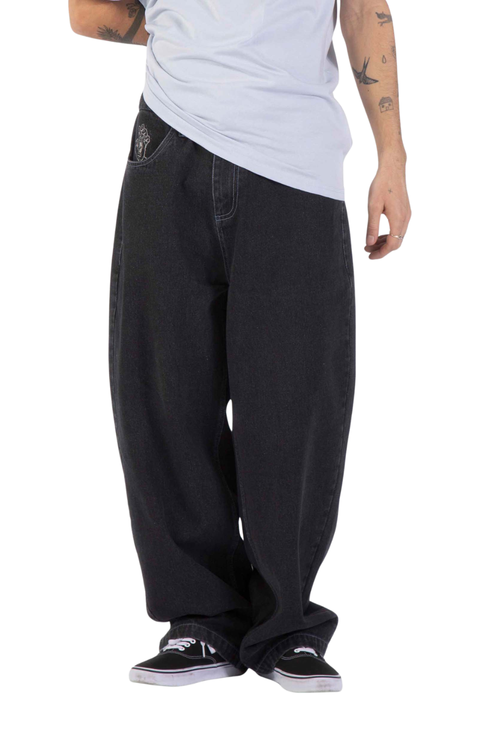 A person wearing very baggy black jeans with a light gray t-shirt and black sneakers, shown from the waist down against a white background.