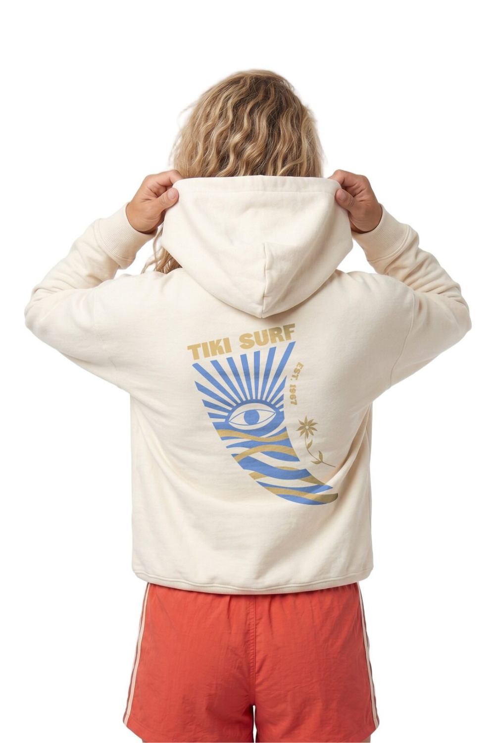 Person wearing a cream hoodie with 'Tiki Surf' design on the back, standing against a white background.