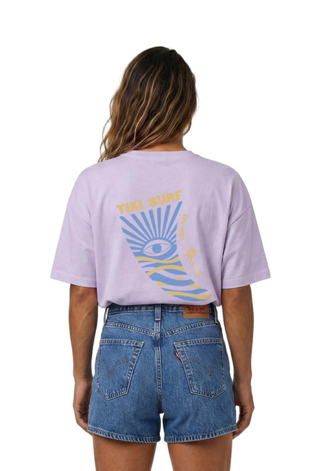 Person wearing a lilac t-shirt with a graphic design on the back standing against a white background