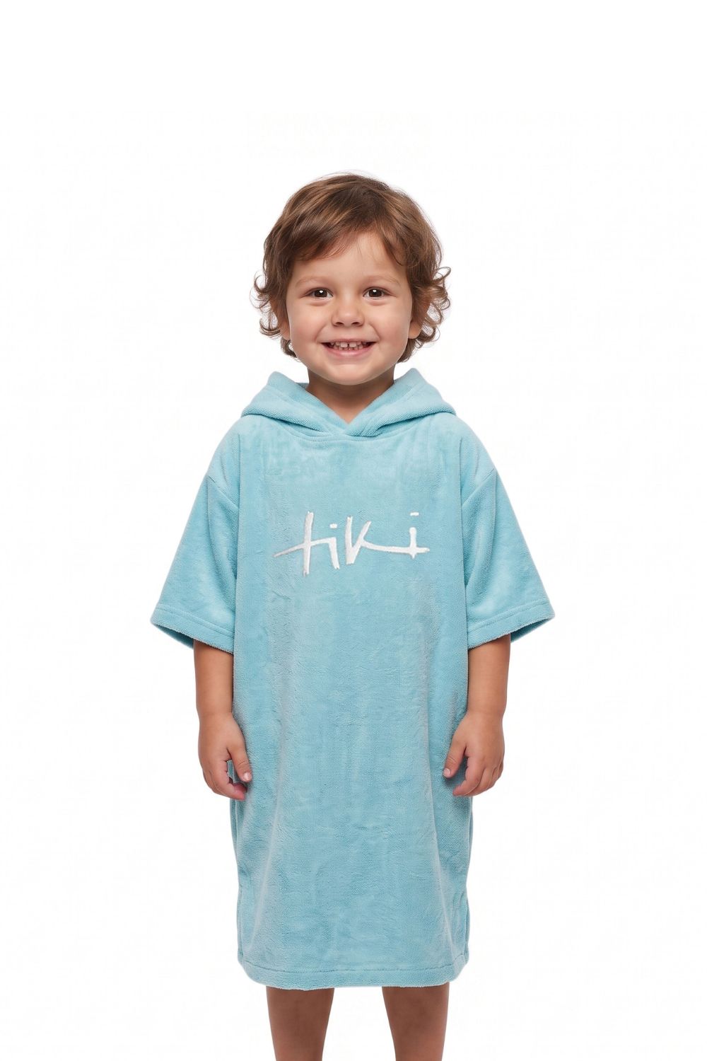 A young child wearing a light blue hooded towel dress with a white 'Tiki' logo on the chest, standing against a plain white background.