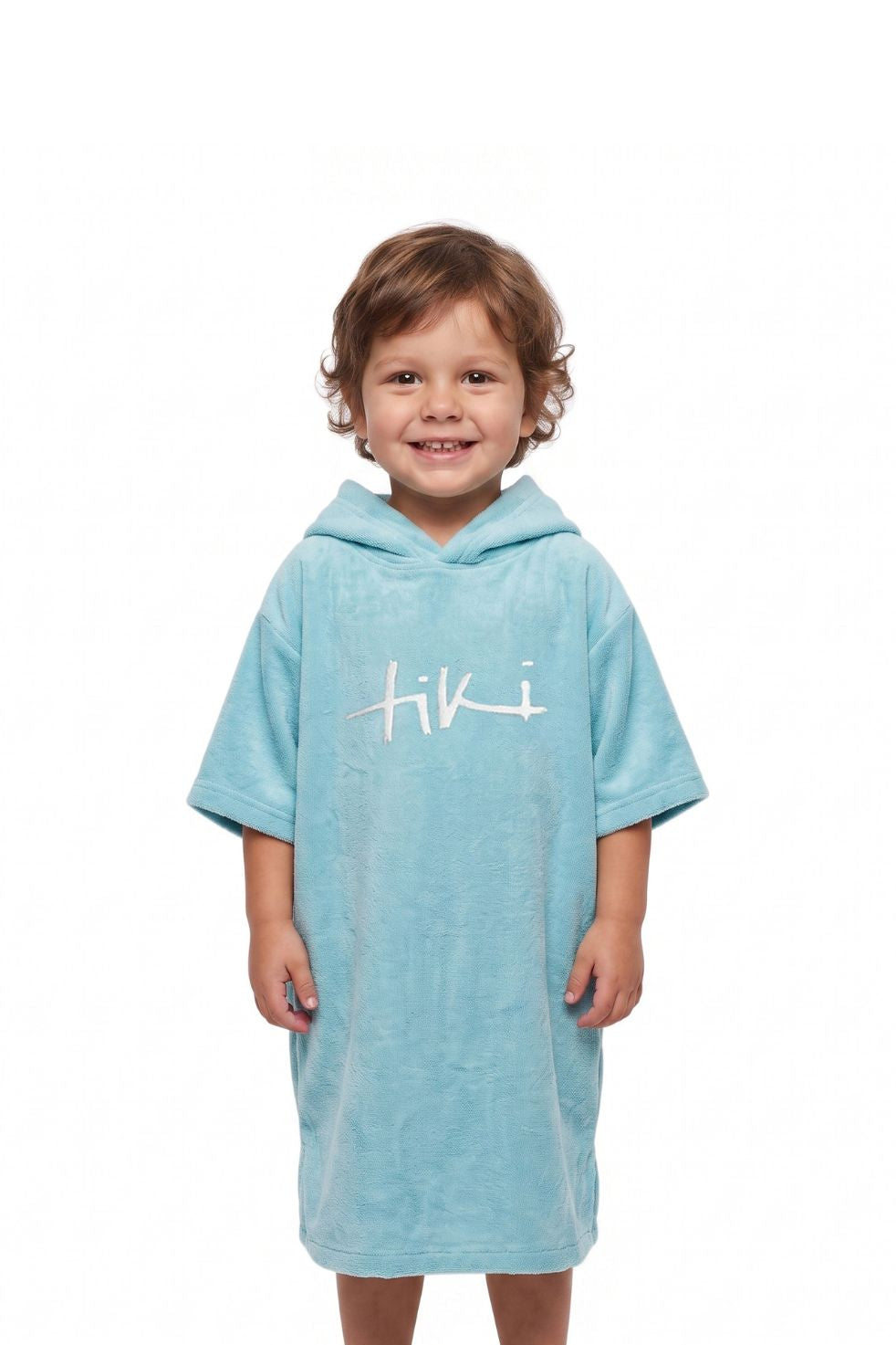 A young child wearing a light blue hooded towel dress with a white 'Tiki' logo on the chest, standing against a plain white background.