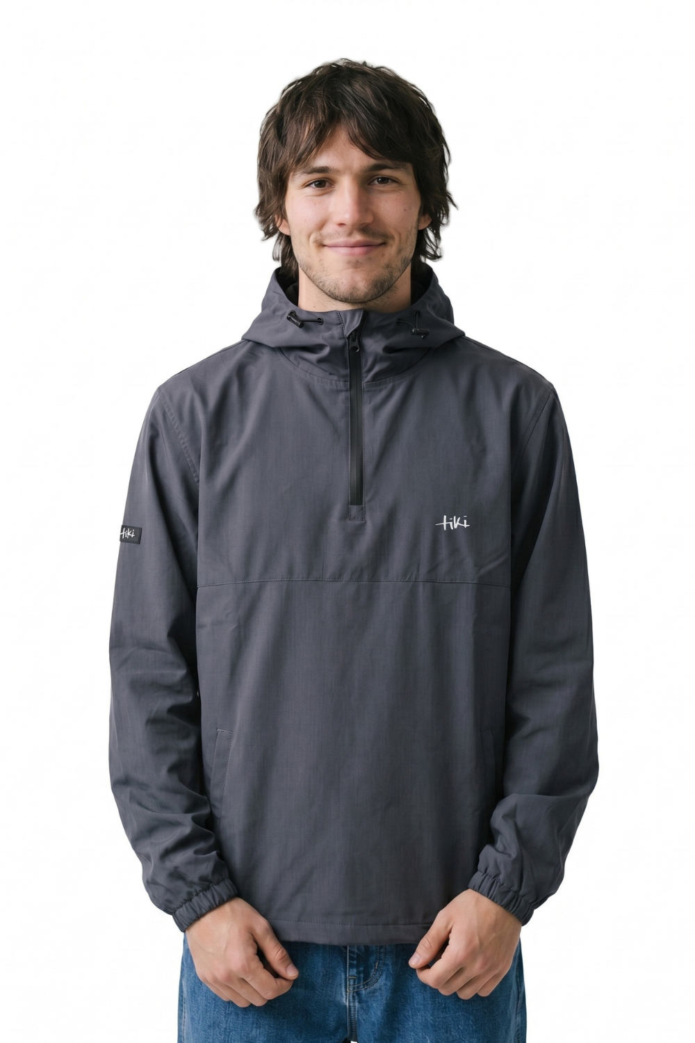 Man wearing a dark navy 1/4 zip jacket with a Tiki logo on the chest